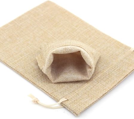 Los bolsos del regalo con el lazo, las chucherías de lino de los bolsos del caramelo de los bolsos de arpillera empaquetan para el banquete de boda de la Navidad